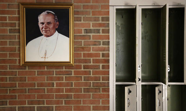  A portrait of St. John Paul II hangs beside a row of empty lockers in the main hallway of Quigley Catholic High School in Baden, Pa. on Monday. Jessie Wardarski | AP photo 