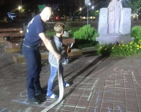  A photo provided to the Times Leader early Saturday shows Capt. Dave Roberts of the Wilkes-Barre Fire Department, together with a young man, hosing down the Christopher Columbus statue on Public Square early Saturday. Submitted 