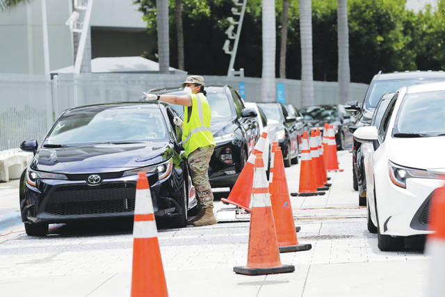 <p>A member of the Florida National Guard monitors vehicles waiting in line outside of Marlins Park at a COVID-19 testing site. Behavior away from the ballpark will be a big factor in determining whether MLB’s attempt to salvage the 2020 season can succeed.</p> <p>Lynne Sladky | AP photo</p>