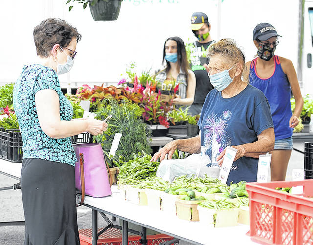 <p>Matriarch Audrey Golomb, right, of Golomb’s Farm & Greenhouse, assists Karen Coco, of Exeter, with her purchase of fresh vegetables.</p> <p>Tony Callaio | For Sunday Dispatch</p>