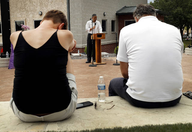 <p>Pittston City Main Street Manager Mary Kroptavich and Mayor Michael Lombardo bow their heads as Pastor Samuel Washington leads a prayer for the victims of COVID-19 at the amphitheater located behind the Pittston Library on Sunday.</p> <p>Fred Adams | Times Leader</p>