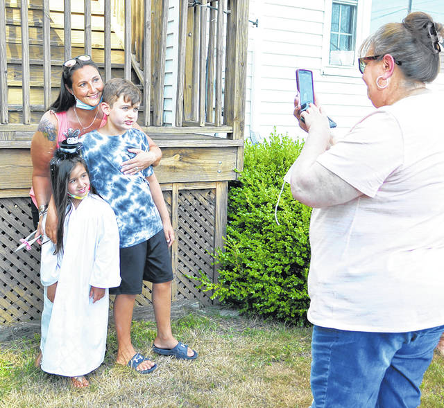 <p>Grandmother Susan Kandrack, right, takes a photo of her daughter, Amy Toma, and grandchildren, graduate Gia and Julian.</p> <p>Tony Callaio | For Sunday Dispatch</p>