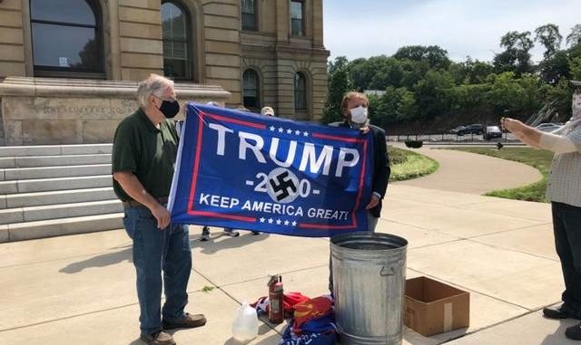  Activist Gene Stilp, right, holds a Trump campaign flag emblazoned with a swastika prior to burning it as part of a protest at the Luzerne County Courthouse on Thursday morning. Roger DuPuis | Times Leader 