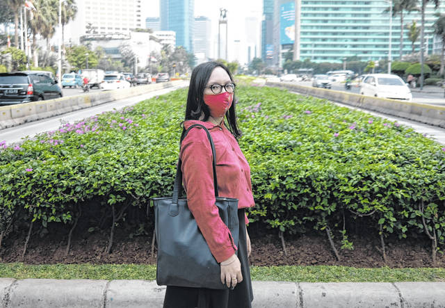 <p>Clara Karina poses for a photo as she waits to cross a road after a job interview at the main business district in Jakarta, Indonesia. In Indonesia, Clara Karina, 25, graduated in January with an accounting degree from a well-known business and finance school in Jakarta. She wanted to work as a civil servant but applied for jobs at private firms as the government froze recruitment. It’s been far from the easy process she imagined.</p> <p>AP photo</p>