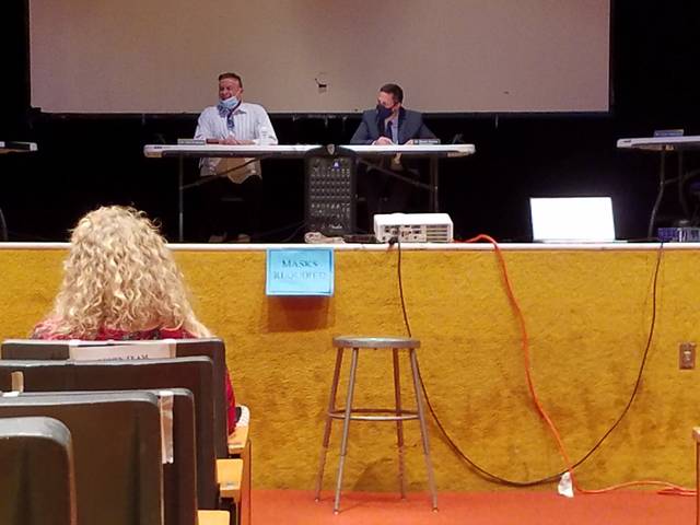 <p>A sign at the edge of the stage notes the mandate to wear masks as Greater Nanticoke Area School Board President Tony Prushinski, left, and Superintendent Ron Grevera, right, begin Thursday’s board meeting. Prushinski wore a mask, but lowered it to be heard more clearly when he spoke into a microphone.</p> <p>Mark Guydish | Times Leader</p>