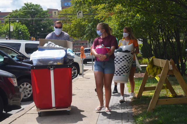 <p>Physician Assistant major Veronica Fenton, center, walks with her dad Michael, left, and mom Suzie as they move her belongings into Essef Hall at King’s College Tuesday. Being a first-year student, Veronica spent her last months in high school learning online at home, and is starting college wearing a mask, but said she feels “pretty safe” starting with all her classes in-person.</p> <p>Mark Guydish | Times Leader</p>