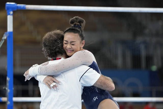 <p>Sunisa Lee, of the United States, embraces her coach Jeff Graba after performing on the uneven bars during the artistic gymnastics women’s all-around final at the 2020 Summer Olympics, Thursday, July 29, 2021, in Tokyo. (AP Photo/Gregory Bull)</p>