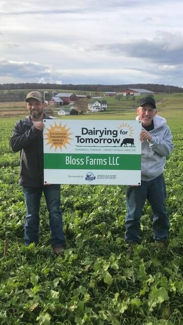 <p>Jeff Bloss, left, and his father, Barry Bloss, display their Dairying For Tomorrow award sign.</p>
                                 <p>Submitted Photo</p>