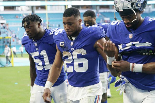 
			
				                                New York Giants outside linebacker Azeez Ojulari (51), running back Saquon Barkley (26) and wide receiver Darius Slayton (86) walk off the field at the end of an NFL game Sunday in Miami Gardens, Fla. The Dolphins defeated the Giants 20-9.
                                 AP photo

			
		