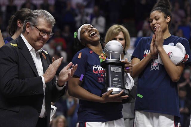 
			
				                                Connecticut’s Christyn Williams, center, reacts after receiving the tournament’s most outstanding player award as head coach Geno Auriemma, left, and Olivia Nelson-Ododa, right, look on after an NCAA basketball game against Villanova in the Big East tournament finals at Mohegan Sun Arena last week in Uncasville, Conn.
                                 AP photo

			
		