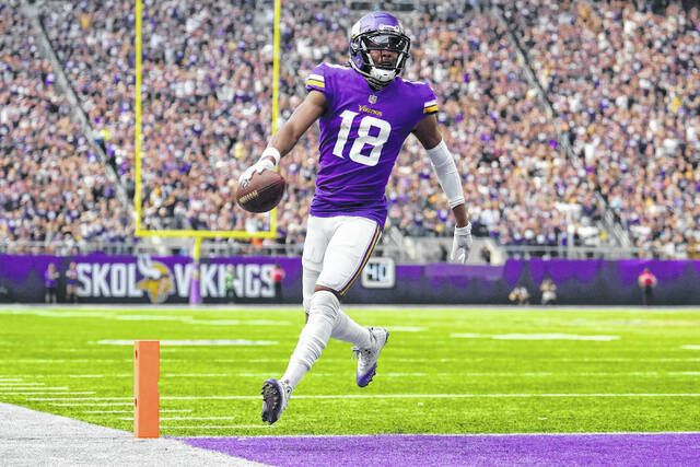 Justin Jefferson of the Minnesota Vikings runs with the ball after a