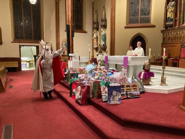 <p>Saint Nicholas greets members of the clergy during the feast day Mass celebrating the saint, who was known for his generosity. The toys collected on the altar were donated by families in the Saint Nicholas Church community, and will go to needy families and charitable organizations.</p>
                                 <p>Kevin Carroll | Times Leader</p>
