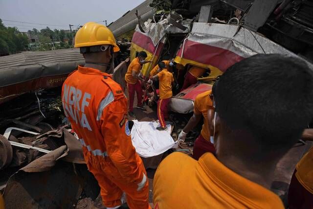 
			
				                                Rescuers carry the body of a victim of a passenger train that derailed in Balasore district, in the eastern Indian state of Orissa, on Saturday. Rescuers are wading through piles of debris and wreckage to pull out bodies and free people after two passenger trains derailed in India, killing more than 280 people and injuring hundreds as rail cars were flipped over and mangled in one of the country’s deadliest train crashes in decades.
                                 AP photo

			
		