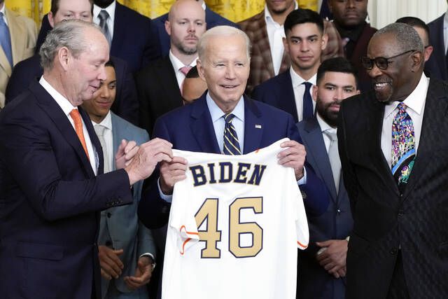 Houston Astros owner Jim Crane and Houston Astros manager Dusty Baker Jr.,  right, present a jersey to President Joe Biden during an event celebrating  the 2022 World Series champion Houston Astros baseball